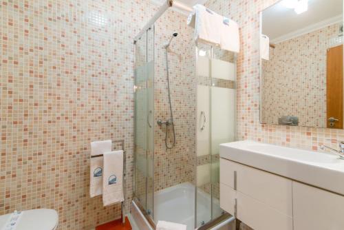 een badkamer met een douche, een wastafel en een toilet bij Casa Mergoux - Maravilhoso Apartamento em Tavira in Tavira