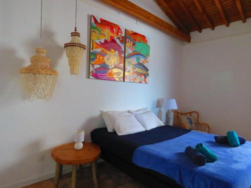 a bedroom with a bed and a table with flip flops on it at Casa do Cais in Monte