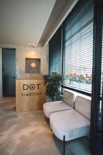 a living room with a couch and aoit tradition sign at Dot Tradition in Vlorë