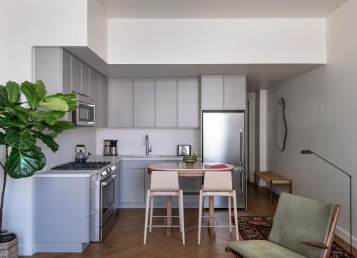 a kitchen with white cabinets and a table and chairs at ROOST Detroit in Detroit