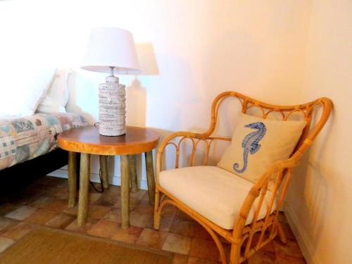 a bedroom with a chair and a table with a lamp at Casa do Cais in Monte