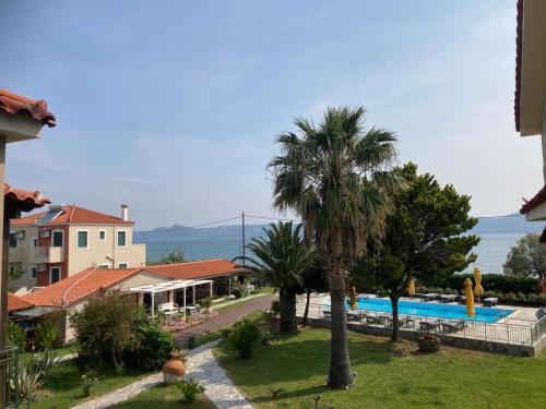un complejo con piscina y palmeras en Ariadnes Holiday Accommodation I, en Apidias Lakos