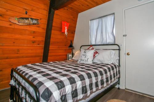 a bedroom with a bed in a room with wooden walls at Bills Big Bear Bunkhouse - Beautiful home within a short drive to all Big Bear has to offer! in Big Bear City