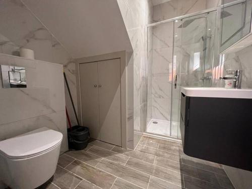 a bathroom with a toilet and a sink and a shower at Star London Finchley Road 1-Bed Sanctuary in London