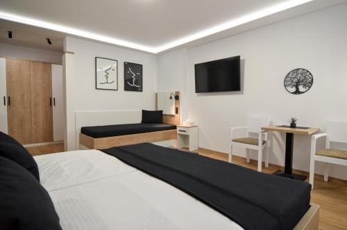 um quarto com uma cama e uma televisão na parede em Residence Malva em Valtice