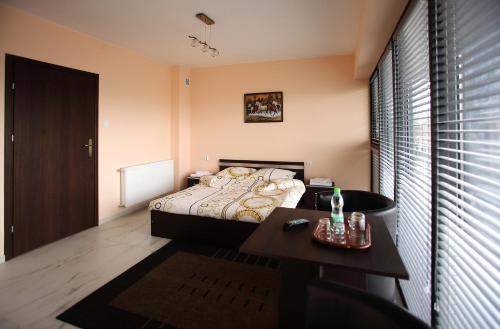 a small bedroom with a bed and a table at Kompleks Perła in Łomża