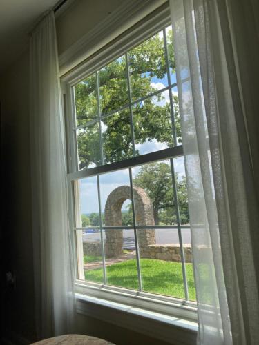 una ventana con vistas a un arco de piedra en The Old Liberty Schoolhouse, en Azle