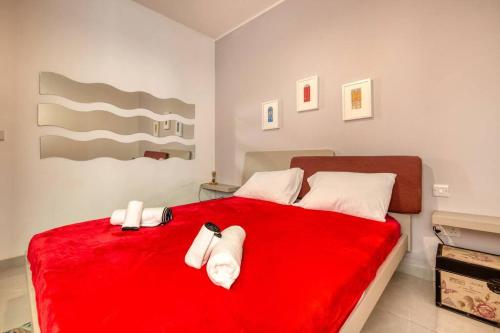 a bedroom with a red bed with towels on it at Mag2 - One of a Kind 3 Bed Rabat in Ħal-Bajjada