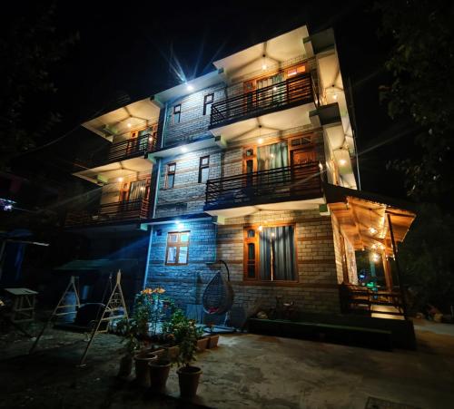 a tall building with lights on it at night at Delight Homestay Kasol in Kasol