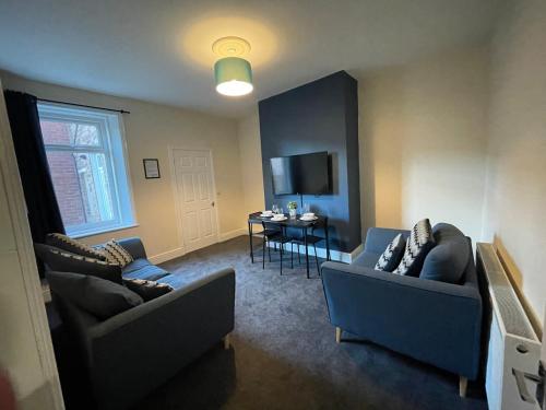 a living room with two couches and a table at Howe - Newly refurbished 2 bedroom flat Free Parking in Gateshead