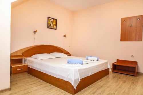 a bedroom with a large bed with two blue chairs at Ravda Bay Guest House in Ravda