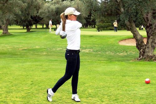 a woman is swinging a golf ball in a park at 718 Rufino Petit Hotel in Mendoza