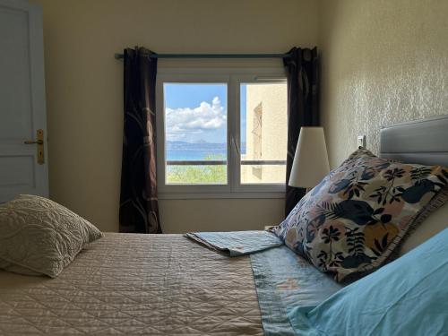 a bedroom with a bed with a view of the ocean at F2 apartments with panoramic sea views in Farinole