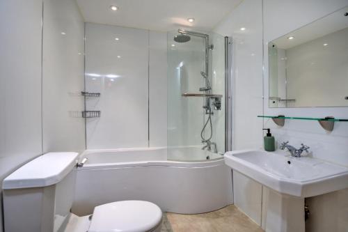 baño blanco con bañera, aseo y lavamanos en Finest Retreats - Victory Mill - Apartment One, en Pickering