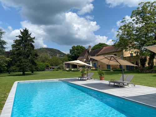 une piscine devant une maison dans l'établissement Par La Rivière, à La Roque-Gageac
