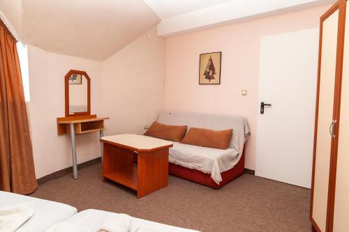 a small room with a bed and a mirror at Ravda Bay Guest House in Ravda
