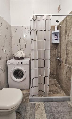 a bathroom with a toilet and a shower and a washing machine at GARNET 3 in Kalamata