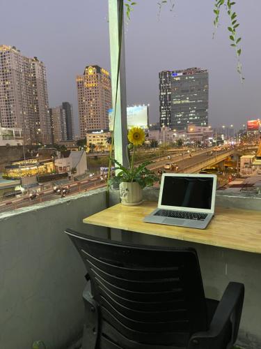 a laptop sitting on a table with a view of a city at Sky Space Bến Thành in Ho Chi Minh City
