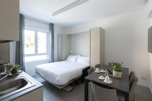 a bedroom with a bed and a kitchen with a sink at Bnbook Residenza Locatelli in Rho