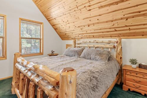 1 dormitorio con cama de madera y techo de madera en Papa Bear's Hideout - Dream Getaway with Hot Tub and Game Room!, en Big Bear Lake