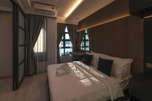 a bedroom with a bed with white sheets and pillows at Bornean Milieu @ JQ Kota Kinabalu in Kota Kinabalu