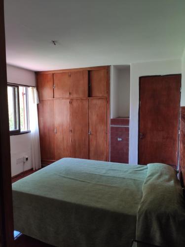 ein Schlafzimmer mit einem großen Bett und Holzschränken in der Unterkunft Molle in Villa Cura Brochero