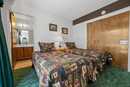 Habitación de hotel con 2 camas y espejo en Boulder Bay Chalet Condo - Mountain charm condo with lake view and WIFI!, en Big Bear Lake
