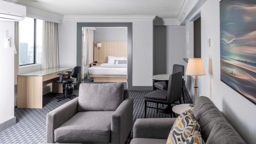 a hotel room with a couch and a bed at Century Plaza Hotel in Vancouver