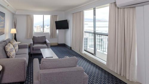 a living room with a couch and chairs and a large window at Century Plaza Hotel in Vancouver