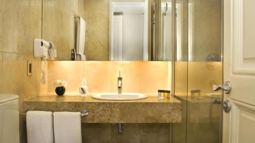 a bathroom with a sink and a mirror at 725 Continental Hotel in Buenos Aires
