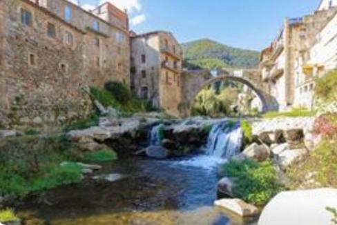 una pintura de una cascada en una ciudad en Escapada rural para descansar - Cicloturismo - Provincia Girona, en Osor