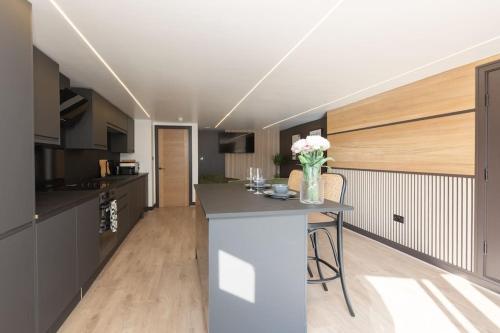 a kitchen with a island in the middle of a room at Stylish & Comfy Promenade Gem ~ Steps to the Beach in Blackpool