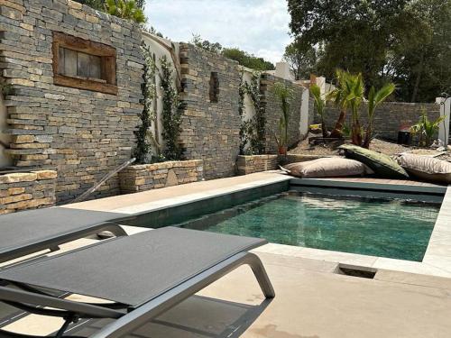 einen Pool vor einer Backsteinmauer in der Unterkunft villa avec piscine loft cabane in Nîmes