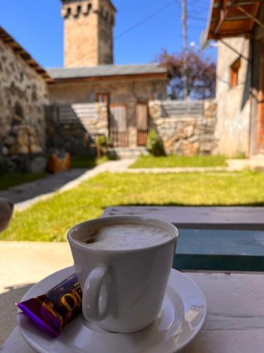 a cup of coffee sitting on a table with a snack at Old View in Mestia