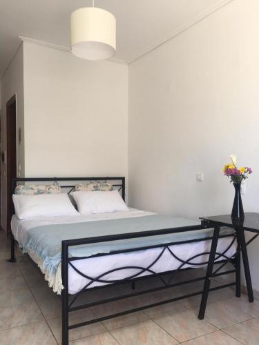 una camera da letto con un letto e un vaso di fiori di Layla' s Petite Home a Città di Kos