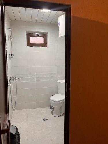 a bathroom with a white toilet and a shower at Old View in Mestia