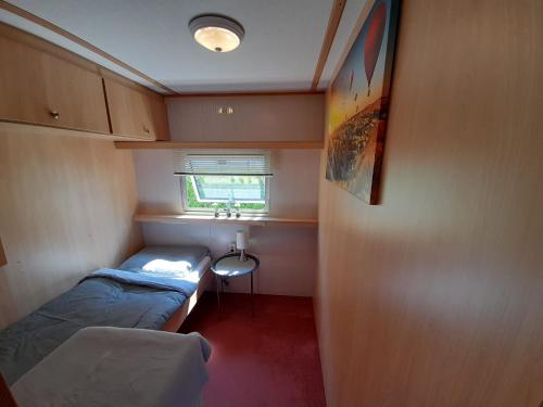 フィールハウテンにあるHoliday in Holland - no workmen only holiday makersのベッド2台とシンクが備わる小さな客室です。