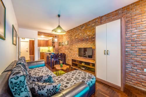 ein Wohnzimmer mit Sofa und Ziegelwand in der Unterkunft Ohrid Boutique Apartments in Ohrid