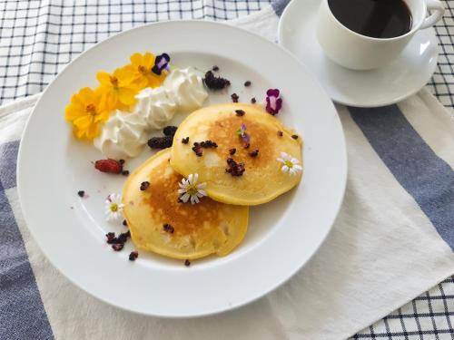 a plate with two pancakes and a cup of coffee at Kanchanaburi City Hotel in Kanchanaburi