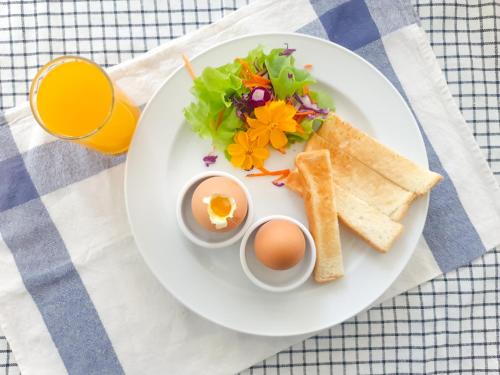 a plate of food with eggs and toast on a table at Kanchanaburi City Hotel in Kanchanaburi