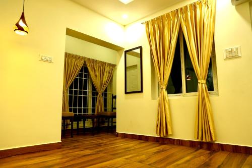 a living room with yellow curtains and wooden floors at JACK'S DEN residency in Puducherry