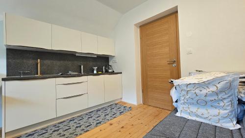 a kitchen with white cabinets and a wooden door at Apartma Sava-Stol in Jesenice
