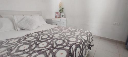 1 dormitorio con 1 cama con edredón blanco y negro en Casa MeyMar, en Mompós