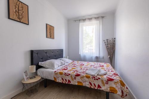 sypialnia z łóżkiem z czerwonym i żółtym kocem w obiekcie Rue Bien Assis avec jardin terrasse w mieście Clermont-Ferrand