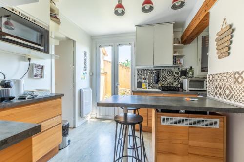 a kitchen with white cabinets and a black counter top at Rue Bien Assis avec jardin terrasse in Clermont-Ferrand