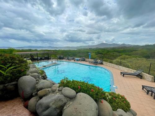 uma piscina com uma parede de pedra à volta em Villa Pura Vida em Matapalo