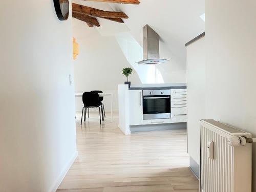 a kitchen with white cabinets and a table with a chair at One Bedroom Apartment In Esbjerg, Smedegade 19 in Esbjerg