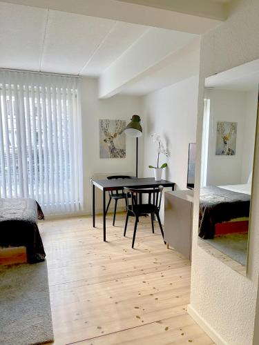 ein Esszimmer mit einem Tisch und ein Schlafzimmer in der Unterkunft Great Modern Studio in Aalborg