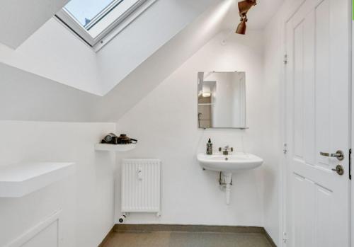 Baño blanco con lavabo y espejo en One Bedroom Apartment In Aarhus, Ole Rmers Gade 104 en Aarhus
