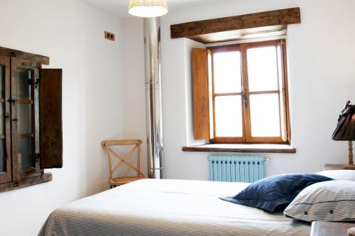Schlafzimmer mit einem Bett und einem Fenster in der Unterkunft Casa del Conde 2 - Ajanedo in Ajanedo